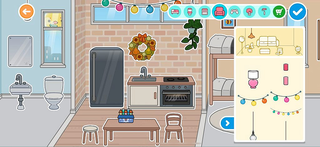 A small, cozy room with a kitchenette, fridge, and table with stools. A wreath hangs on the wall, and a string of festive lights is displayed along with various other decorative items.