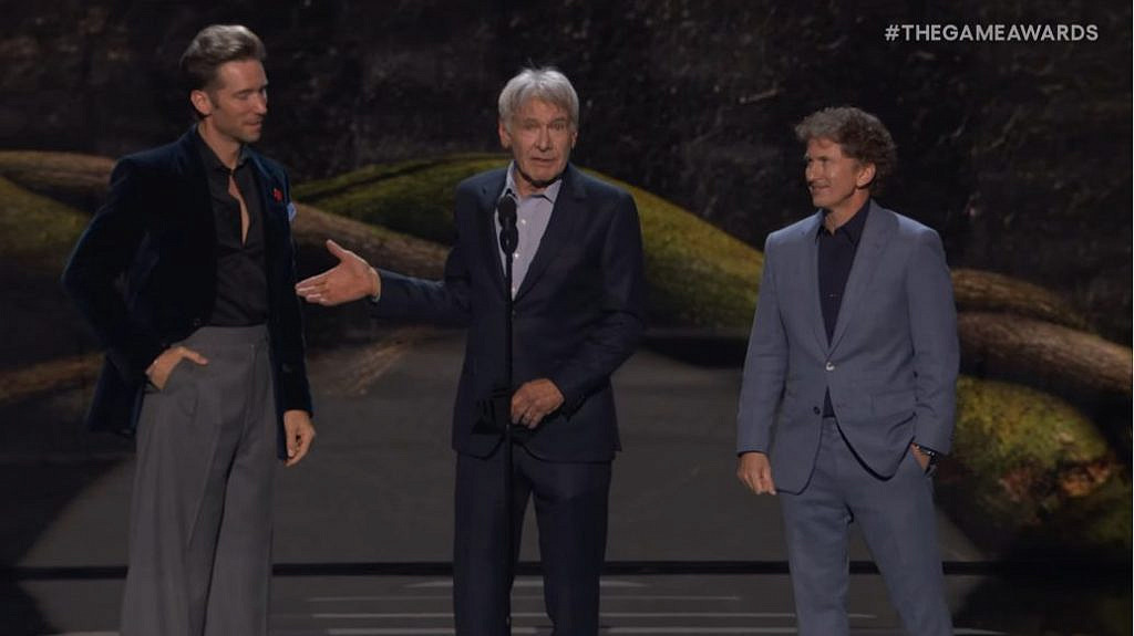 Three men in suits presenting an award on stage.